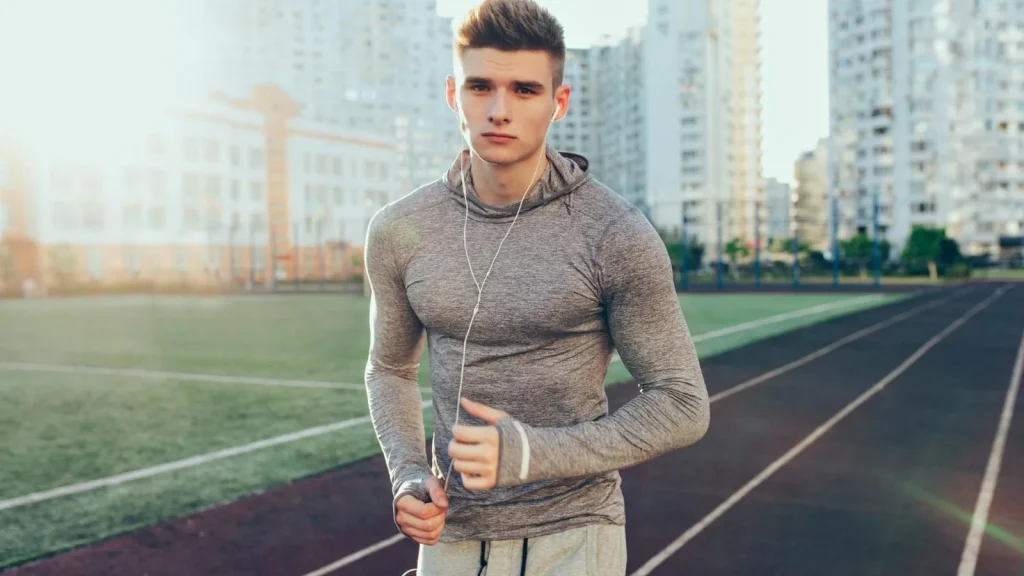Biegacz w stroju sportowym porusza się po bieżni na stadionie